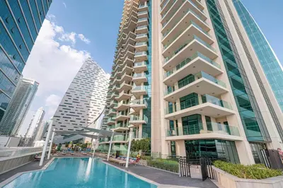a tall building with a swimming pool in front of it at Mahogany 20 - 1BR 4PAX - Infinity Pool & Spacious in Dubai