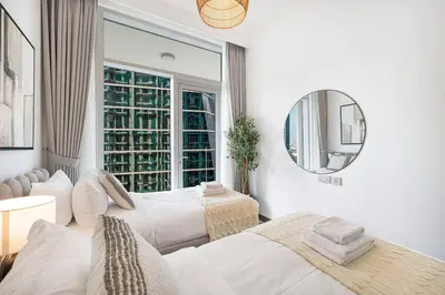 a living room with white furniture and a large window at Mahogany 19 - 2BR 6PAX - Infinity Pool Stylish Flat in Dubai