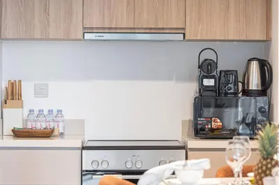 a kitchen with a counter with a stove top oven at Mahogany 19 - 2BR 6PAX - Infinity Pool Stylish Flat in Dubai