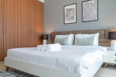 a bedroom with a large white bed with two towels at StayShort - Premium 2BR in Dubai Marina - Sleeps 4 in Dubai
