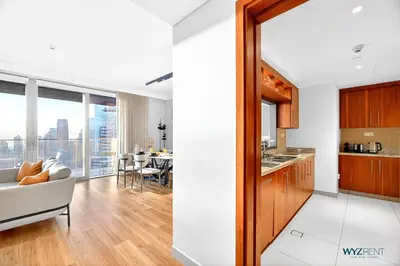 a kitchen and living room with a couch and a table at Iconic 4BR with Burj & Fountain Views Boulevard Point in Dubai