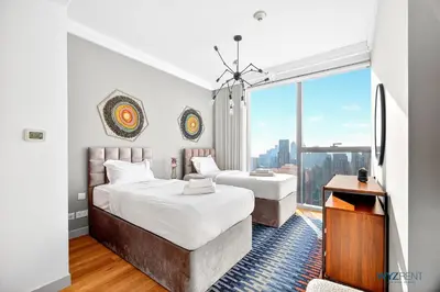 two beds in a room with a large window at Iconic 4BR with Burj & Fountain Views Boulevard Point in Dubai
