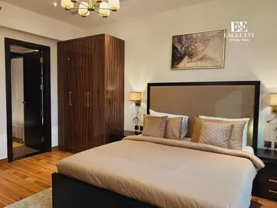a bedroom with a large bed and a chandelier at Spacious 1 Bed with Burj Khalifa View accommodates 3 or 4 in Dubai