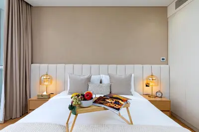 a bedroom with a bed with a tray of food on it at Maison Privee - Chic Downtown Living with Dubai Cityscape Views in Dubai