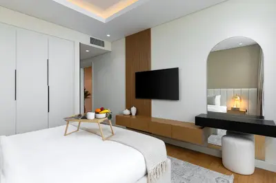 a bedroom with a bed and a tv on a wall at Maison Privee - Chic Downtown Living with Dubai Cityscape Views in Dubai