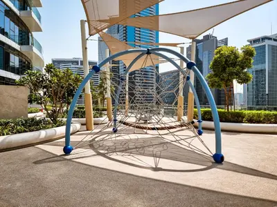 a large metal structure with a swing in a city at Downtown Luxury 2 Bedroom Apartment with Iconic Burj Khalifa Views, Rooftop Pool, Movie Room, Squash Court, and Kids Club in Dubai