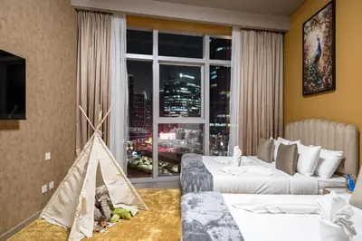 a hotel room with two beds and a window at Downtown Luxury 2 Bedroom Apartment with Iconic Burj Khalifa Views, Rooftop Pool, Movie Room, Squash Court, and Kids Club in Dubai