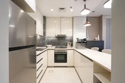 a kitchen with white cabinets and a stove at Trophy Soft tones sharp style Masterpiece 705 in Dubai