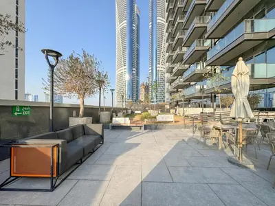 a patio in a building with a couch and tables and chairs at Trophy Soft tones sharp style Masterpiece 705 in Dubai