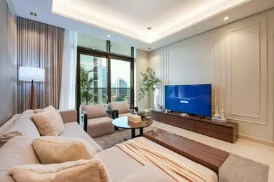 a living room with a couch and a tv at Trophy Soft tones sharp style Masterpiece 705 in Dubai