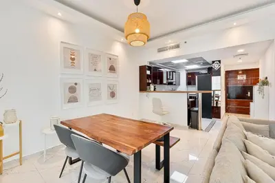 a living room with a wooden table and a couch at Modern 2 Bed with Waterfront Views, Gym & Pool in Dubai