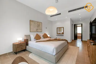 a bedroom with a large white bed and a table at Brand new Large Villa JVT Private Garden in Dubai