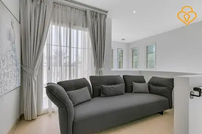 a living room with a couch in front of a window at Brand new Large Villa JVT Private Garden in Dubai