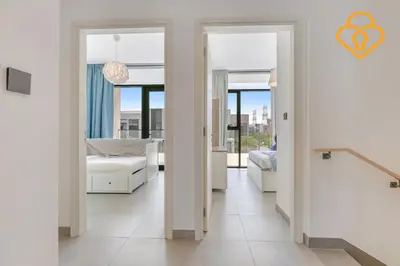 a bedroom with white walls and doors with a bed at 3 BR W Maid Walk to Pool, Arabian Ranches III Ruba in Dubai
