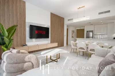 a living room with a table and a kitchen at LUX The Creekside Skyline View Suite in Dubai