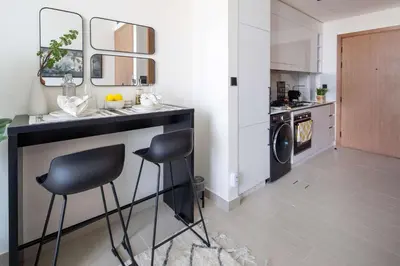 a kitchen with a counter and two stools in a room at Frank Porter - Binghatti Azure in Dubai