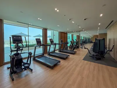 a gym with a row of treadmills and exercise equipment at Frank Porter - Binghatti Azure in Dubai