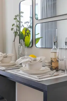 a table with plates and glasses and a mirror at Frank Porter - Binghatti Azure in Dubai