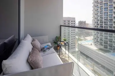 a living room with a white couch and a large window at Frank Porter - Empire Residence, JVC in Dubai
