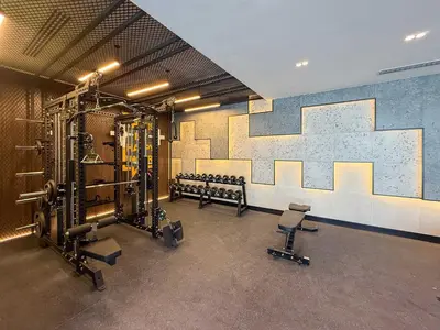 a room with a gym with benches and a mural at Frank Porter - Empire Residence, JVC in Dubai