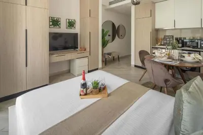a living room and kitchen with a bed and a table at Frank Porter - Empire Residence, JVC in Dubai