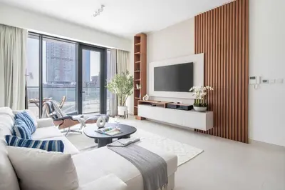 a living room with a white couch and a tv at Frank Porter - Canal Front Residence 9A in Dubai