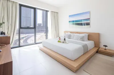 a bedroom with a large bed and a large window at Frank Porter - Canal Front Residence 9A in Dubai