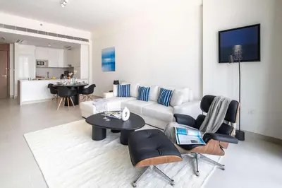 a living room with a couch and a table and chairs at Frank Porter - Canal Front Residence 9A in Dubai