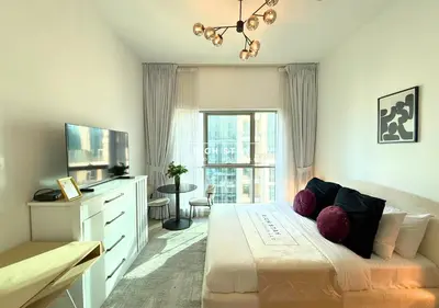 a bedroom with a large bed and a large window at Boulevard Charm- Studio Hideaway in Dubai