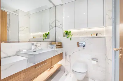 a white bathroom with a sink and a toilet at Elegant & Cozy Home with Stylish Modern Interiors in Dubai