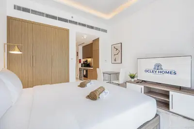 a bedroom with a white bed and a flat screen tv at Elegant & Cozy Home with Stylish Modern Interiors in Dubai