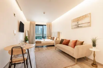 a living room with a couch and a table at FIRST CLASS Studio Modern Elegance in Dubai