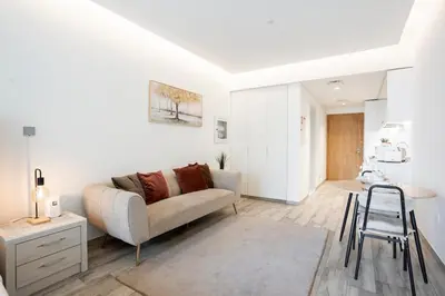 a living room with a couch and a stool at FIRST CLASS Studio Modern Elegance in Dubai
