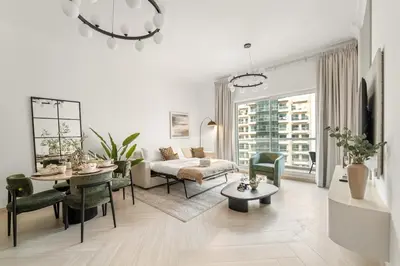 a living room with a couch and a table and chairs at FIRST CLASS 1BR Canal Views , Gem of Mayfair in Dubai
