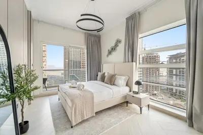 a bedroom with a white bed and large windows at FIRST CLASS 1BR Canal Views , Gem of Mayfair in Dubai