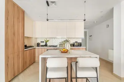 a kitchen with a large island with white cabinets at FIRST CLASS 1BR Canal Views , Gem of Mayfair in Dubai