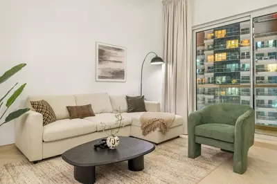 a living room with a couch and a chair and a table at FIRST CLASS 1BR Canal Views , Gem of Mayfair in Dubai