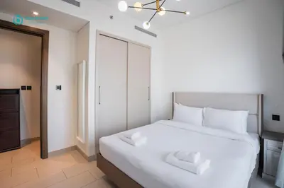 a bedroom with a large white bed with white pillows at Blue Breeze - 2 Bedroom near Downtown, Elegant Retreat in Sobha in Dubai