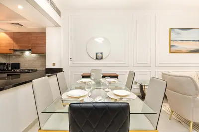 a dining room with a glass table and chairs at Ahlan HH - 1BR Haven with Study Room - Eleganz by Danube in Dubai