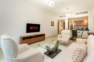 a living room with white furniture and a tv at Ahlan HH - 1BR Haven with Study Room - Eleganz by Danube in Dubai