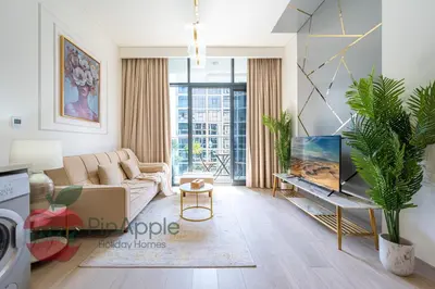 a living room with a couch and a tv at Beautiful1BR Close to Downtown in Dubai