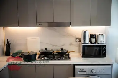 a kitchen with two pots on a stove with a microwave at Beautiful1BR Close to Downtown in Dubai