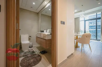 a bathroom with a toilet and a sink and a table at Beautiful1BR Close to Downtown in Dubai