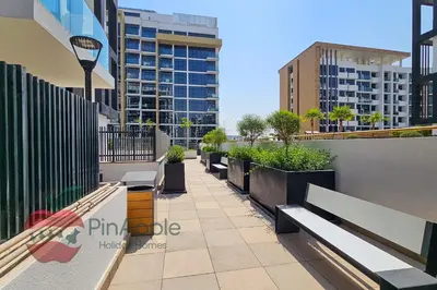 a row of benches on a balcony with buildings at Beautiful1BR Close to Downtown in Dubai
