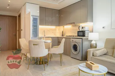 a kitchen and living room with a couch and a table at Beautiful1BR Close to Downtown in Dubai