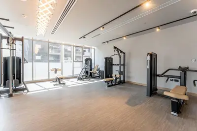 a gym with treadmills and machines in a room at 1BDR with Gym, Sauna, Pool - Opposite Circle Mall in Dubai