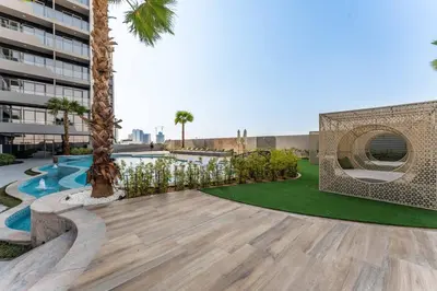 a courtyard with palm trees and a swimming pool at 1BDR with Gym, Sauna, Pool - Opposite Circle Mall in Dubai