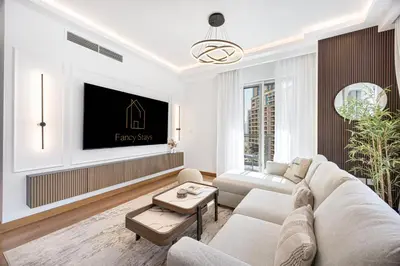 a living room with a couch and a tv at Panoramic Fountain & Burj Khalifa Views, Pool, Gym in Dubai