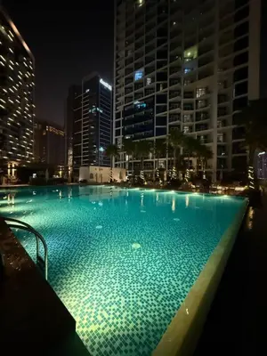 a large swimming pool in a city at night at Elegant Urban Escape in Dubai