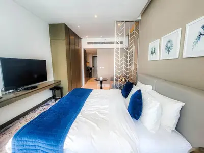 a bedroom with a large white bed with blue pillows at Bright And Spacious Canal View Appartment in Dubai